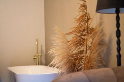 a bathroom with a white tub and some tall grass at Logement In de Peel in Griendtsveen