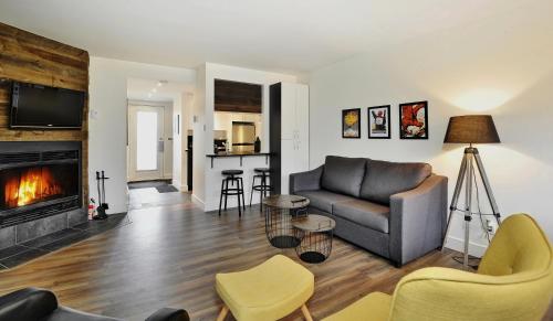 a living room with a couch and a fireplace at Hameau 24#22 - Studio in Stoneham