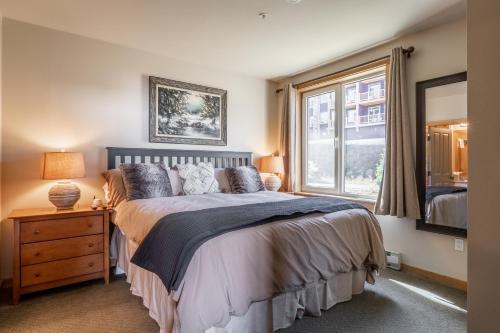 um quarto com uma cama grande e uma janela em Ski in Ski Out Juniper Springs Lodge #351 Luxury Slope-side 2 Bedrm 2 Bath End Unit! em Mammoth Lakes