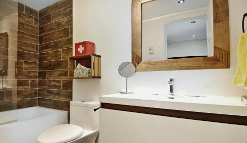 y baño con aseo, lavabo y espejo. en Hameau 24#22 - Studio, en Stoneham