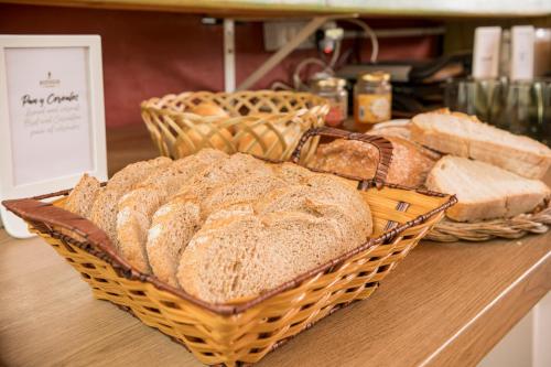 a bunch of breads in baskets on a counter at Hotel Rural El Refugio in Tejeda
