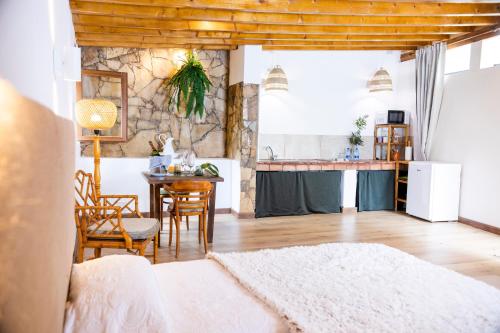 a living room with a table and a kitchen at Hotel Rural El Refugio in Tejeda