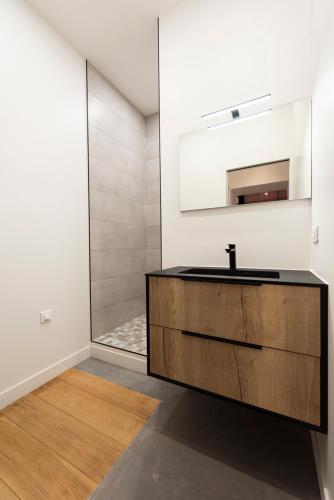 une salle de bain avec un lavabo et un miroir dans l'établissement Paridily Circus, à Paris