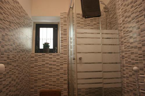ein Bad mit einer ebenerdigen Dusche neben einem Fenster in der Unterkunft Katane Apartment One-Room in Catania
