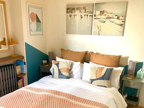 a bedroom with a bed with two pictures on the wall at St Ives Balcony Flat in St Ives