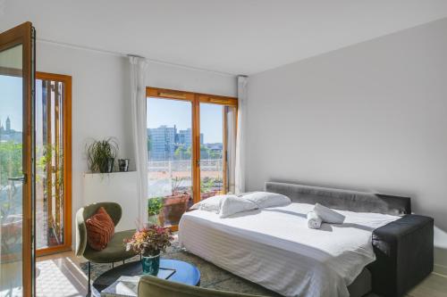 a bedroom with a white bed and a window at Appartement ensoleillé avec vue sur Paris et le Sacré-Cœur by Weekome in Paris