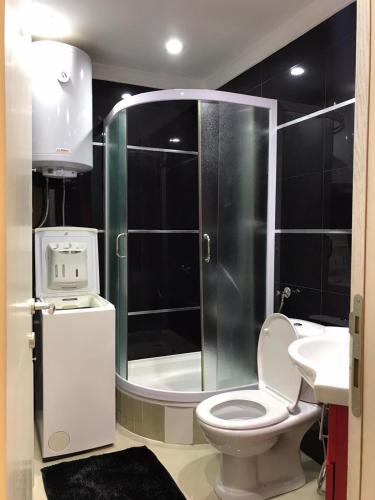 een badkamer met een douche, een toilet en een wastafel bij Paradiso Apartment in Novi Pazar