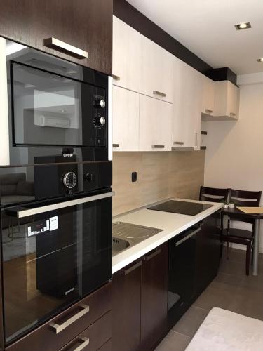 cocina con microondas negro y fogones en Paradiso Apartment, en Novi Pazar