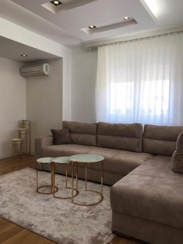 een woonkamer met een bank en een tafel bij Paradiso Apartment in Novi Pazar