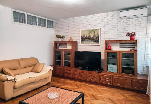 Una sala de estar con un sofá y un televisor de pantalla plana. en Heart of the City, en Banja Luka