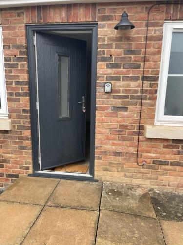 a black door on a brick building with a brick wall at Apple Barn Guest House in Wisbech