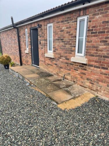 a brick house with a front door and a driveway at Apple Barn Guest House in Wisbech