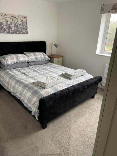 a bed in a bedroom with a black bed frame at Apple Barn Guest House in Wisbech