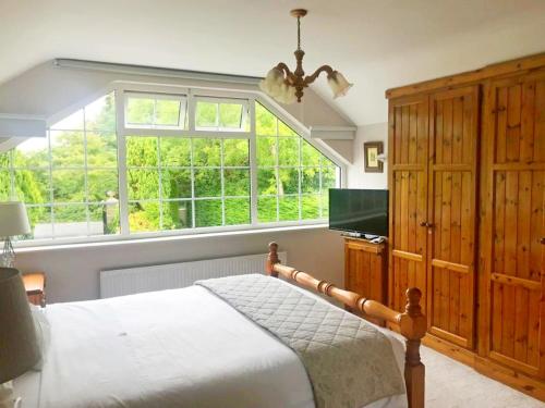 ein Schlafzimmer mit einem Bett und einem großen Fenster in der Unterkunft Leabrook House in Castlemaine