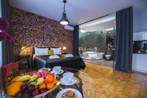 ein Zimmer mit einem Bett und einem Tisch mit Obst darauf in der Unterkunft Leo Apartments Old Town in Krakau