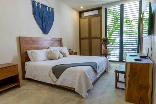 Un dormitorio con una cama, un escritorio y ventanas. en Exquisite Tulum jungle condo w/private pool!, en Tulum