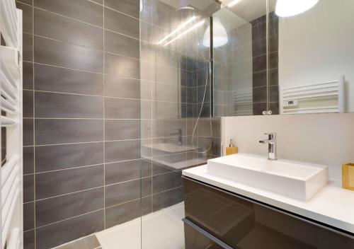 La salle de bains est pourvue d'un lavabo et d'un miroir. dans l'établissement Au COEUR du STADE DE FRANCE, à Saint-Denis
