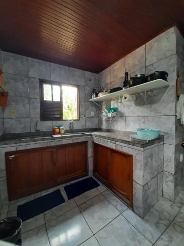 a kitchen with a sink and a window and a counter at Casa ampla com Wi-Fi e garagem para dois veículos in Campos dos Goytacazes