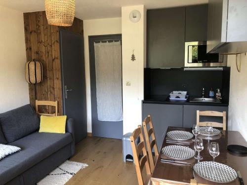 een keuken en een woonkamer met een tafel en een bank bij Appartement Crest-Voland, 1 pièce, 4 personnes - FR-1-595-59 in Crest-Voland