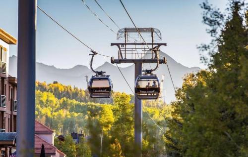 two gondolas on a ski lift in the mountains at Forbes 5 Star Luxury Hotel - 1 Br Ski-in Ski-out Residence in Mountain Village Colorado in Telluride