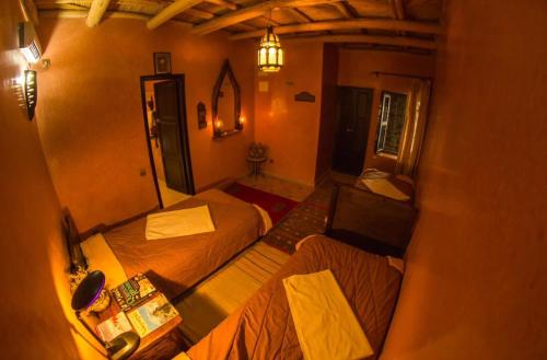 a view of a room with two beds and a table at Riad imlil in Imlil