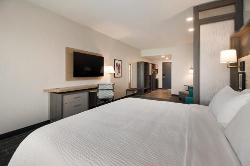 a hotel room with a large bed and a desk at Holiday Inn & Suites - Mt Juliet Nashville Area by IHG in Mount Juliet