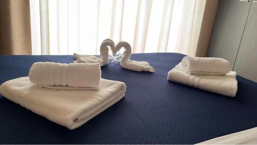 two towels on a blue table with swans on it at ALMA B&B Home Cosenza in Cosenza