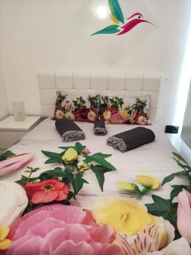 Una cama con flores y almohadas. en Precioso apartamento Centro de Sevilla en Sevilla