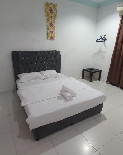 a bed with white sheets and a black headboard in a room at RVH Kuala Terengganu in Kuala Terengganu