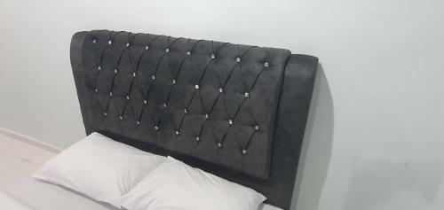 a black headboard of a bed with two white pillows at RVH Kuala Terengganu in Kuala Terengganu