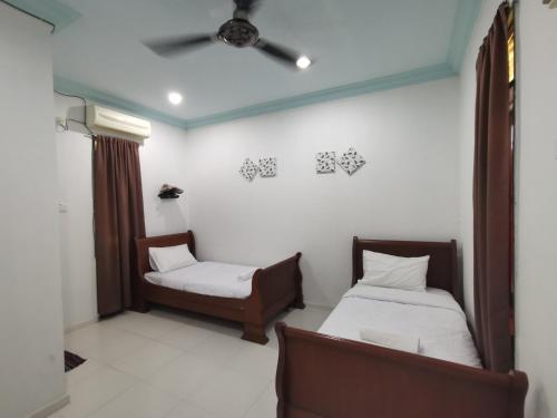 クアラ・トレンガヌにあるRVH Kuala Terengganuのベッド2台と椅子が備わる客室です。