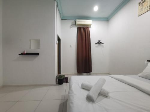 a bedroom with a white bed and a brown curtain at RVH Kuala Terengganu in Kuala Terengganu