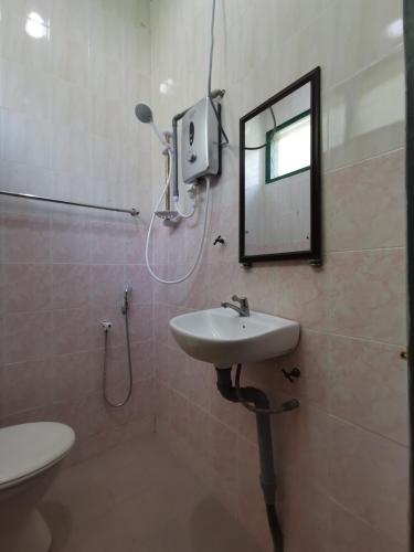 a bathroom with a sink and a mirror and a toilet at RVH Kuala Terengganu in Kuala Terengganu