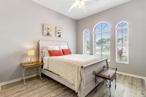 a bedroom with a bed and two windows at Paradiso Probay in Bradenton