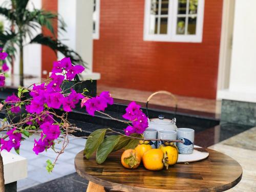 einen Tisch mit Obst und Blumen darauf in der Unterkunft Ninh Binh Brother's Homestay in Ninh Bình