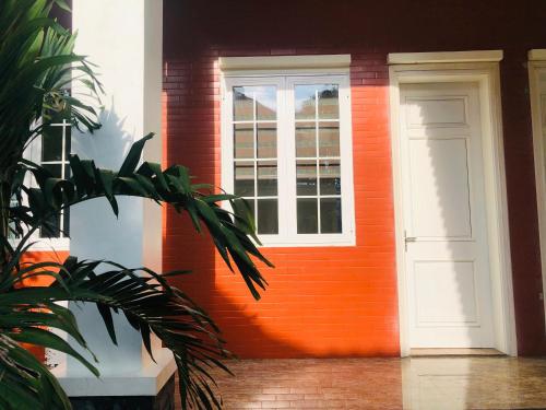 an orange front door of a house with a window at Ninh Binh Brother's Homestay in Ninh Binh