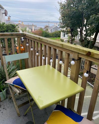 a yellow table and chair on a balcony at St Ives Balcony Flat in St Ives