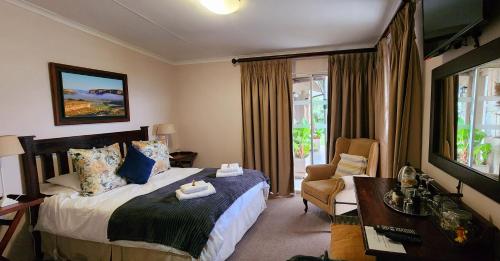 クラレンスにあるAsh River Lodgeのベッドと椅子付きのホテルルーム