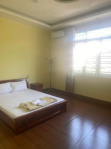 a bedroom with a bed and a large window at Trung Đức Hotel in Hòn Một