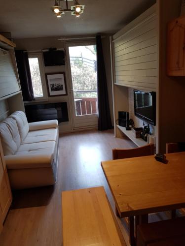 un salon avec un canapé et une table dans l'établissement Edelweiss Prapoutel les 7 Laux, à Les Adrets