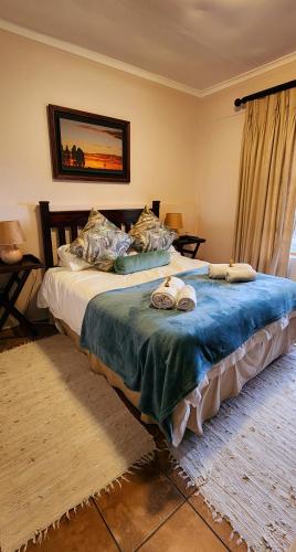 a bedroom with a bed with two towels on it at Ash River Lodge in Clarens