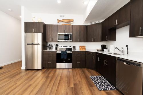 a kitchen with wooden cabinets and stainless steel appliances at UTAH Maritime, FAST WIFI, Conventions, King Bed in Salt Lake City