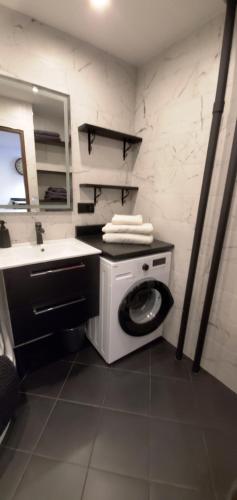 Un baño con lavadora y lavabo. en HAPPY - VIP Apartment - ApartamentyHappy pl, en Tarnów