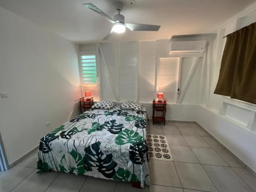 1 dormitorio con 1 cama con edredón verde y blanco en Villa Diam-Arlet en Les Anses-dʼArlets