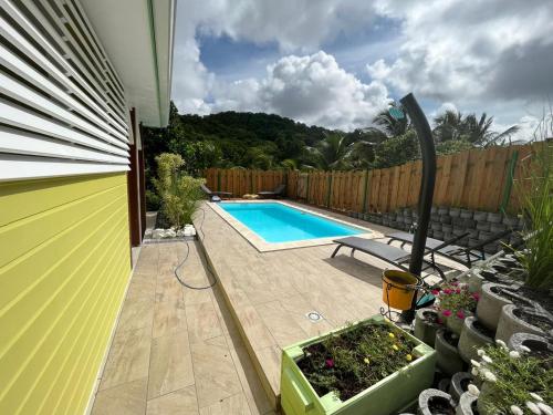 un patio trasero con piscina y valla en Villa Diam-Arlet en Les Anses-dʼArlets