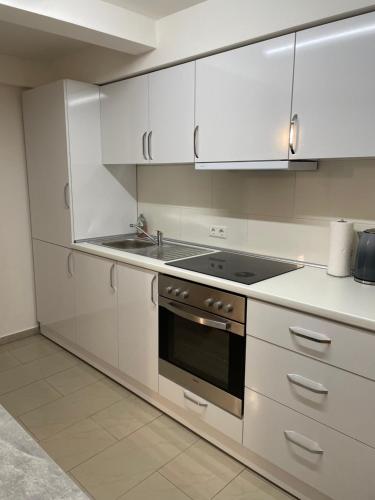een keuken met witte kasten en een fornuis met oven bij Erbacher Wohnung in Erbach