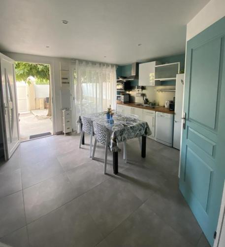 - une cuisine avec une table au milieu d'une pièce dans l'établissement Maison en bord de mer, à Mauguio