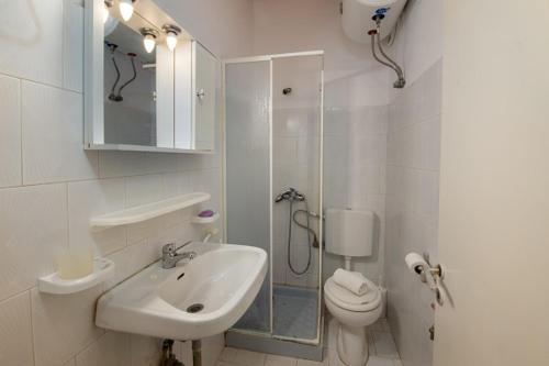 La salle de bains est pourvue d'un lavabo, de toilettes et d'une douche. dans l'établissement Alekos House, à Longós