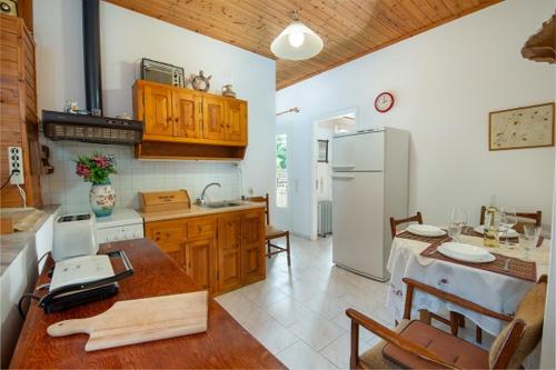a kitchen with a table and a refrigerator at Alekos House in Longós