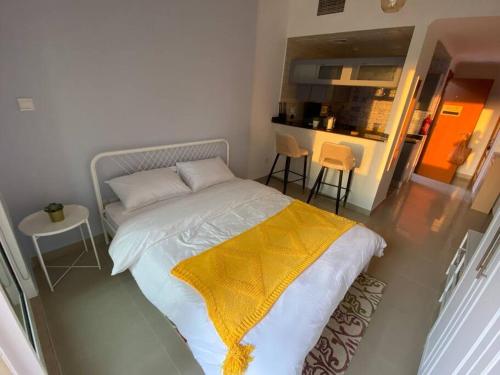 a bedroom with a bed with a yellow blanket on it at Studio apartment in the heart of Dubai Marina. in Dubai